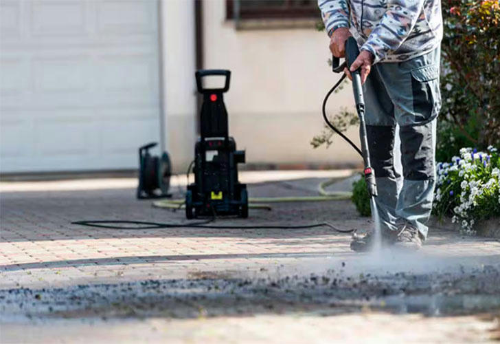 High-pressure washer in action cleaning a driveway